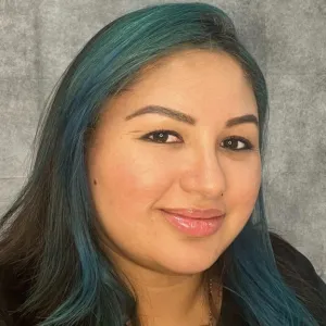 kim is smiling in front of grey wall